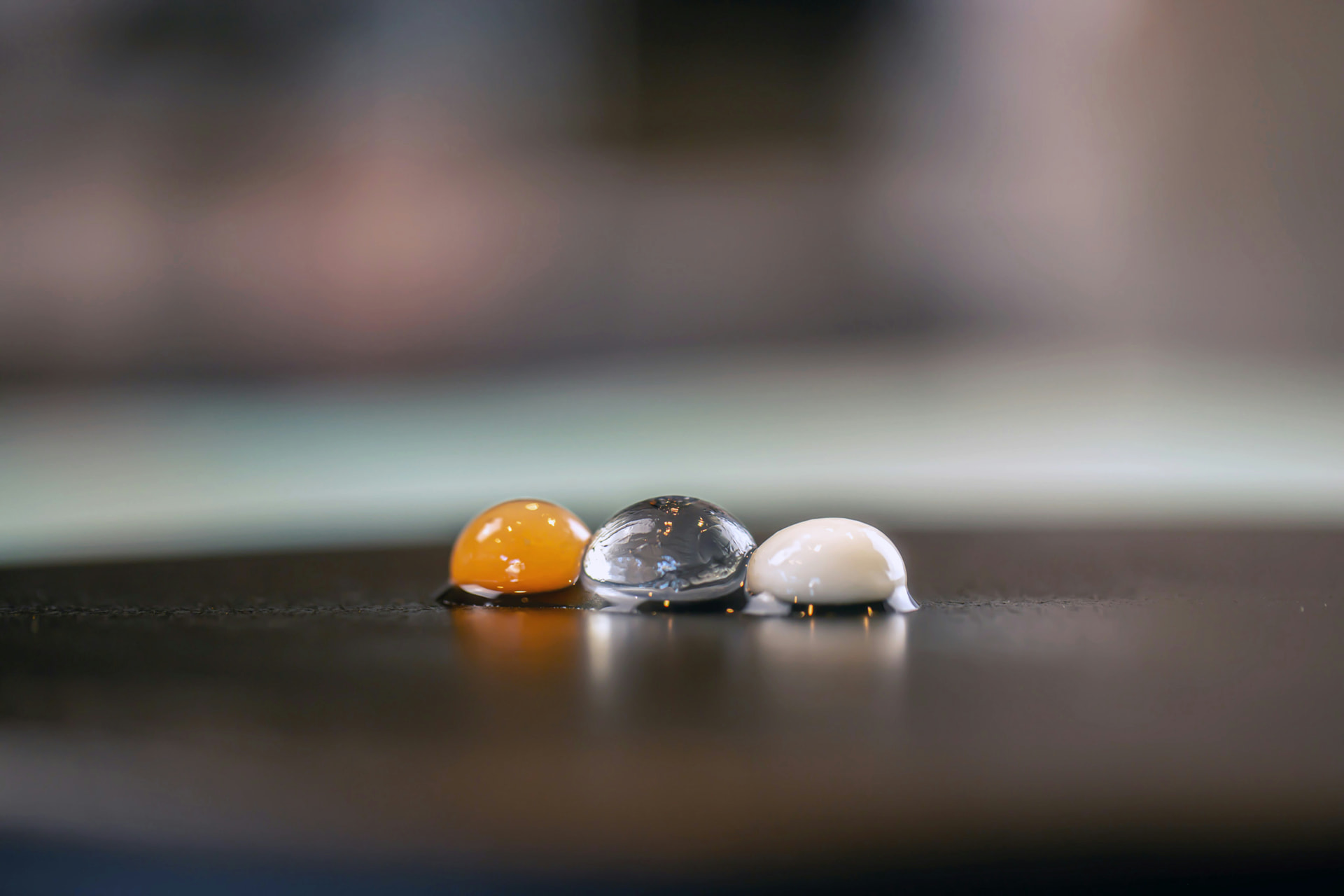 Three translucent spherification pearls in a row
